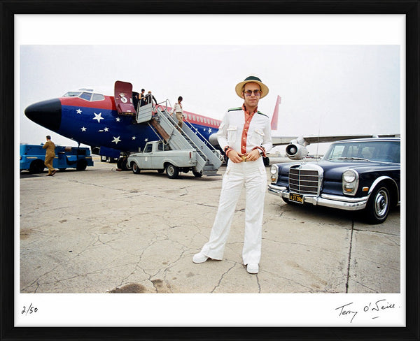 Elton John with his private plane, 1974 — Limited Edition Print, framed - Terry O'Neill