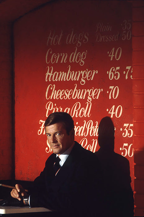 Roger Moore as James Bond smoking a cigar in a diner on the film set of 'Live and let die', 1973 — Limited Edition Print