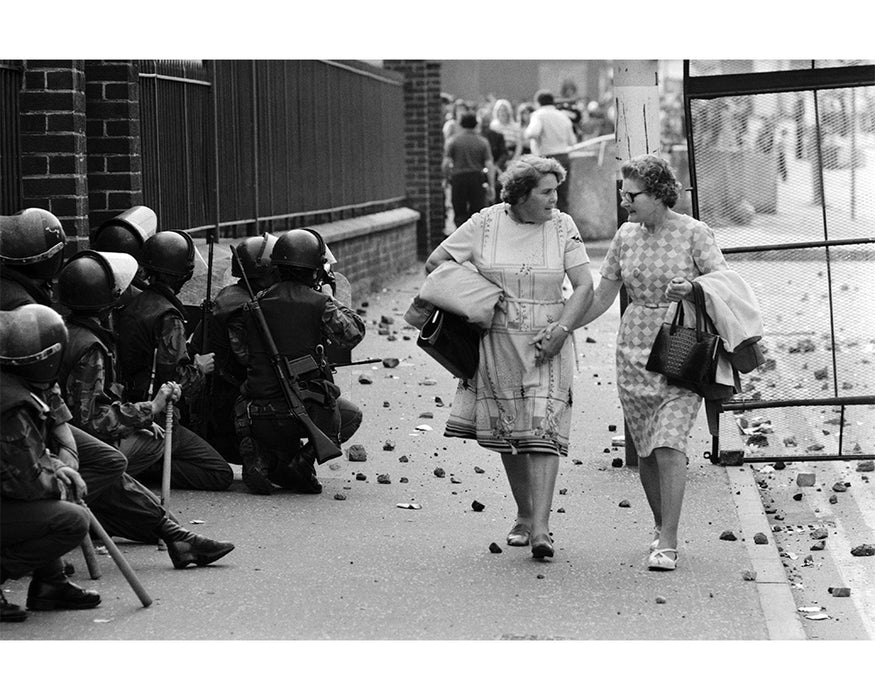 Women passing English soldiers in riot gear, 1977 — Limited Edition Print - Michael Ward